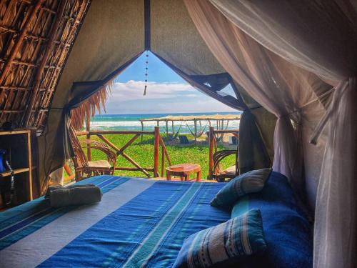 a bed in a tent with a view of the ocean at Entremares in Boca del cielo