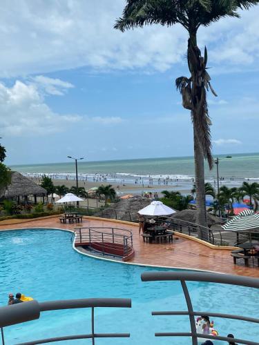 a swimming pool with a view of the beach at Apartamento en Tonsupa - Torresol Tropical in Tonsupa