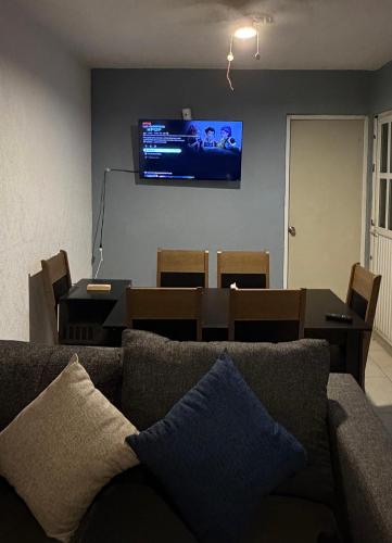 a living room with a couch and a television on a wall at Casa Marquesa 3 Habitaciones in Acapulco