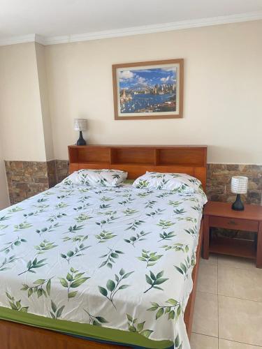 a bedroom with a bed with a green and white comforter at Apartamento en Tonsupa - Torresol Tropical in Tonsupa