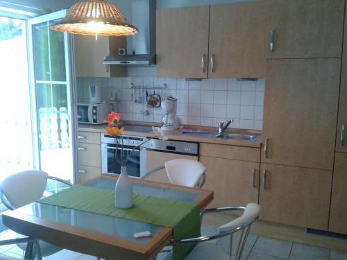 a kitchen with a table and chairs and a table and aendant light at Ferienwohnung Buchenpark in Prerow