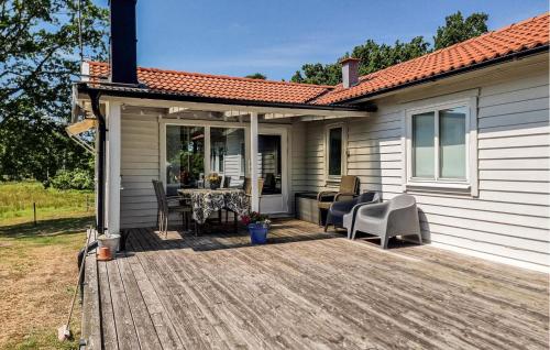 a patio with a table and chairs on a deck at 2 Bedroom Amazing Home In Jämjö in Torhamn