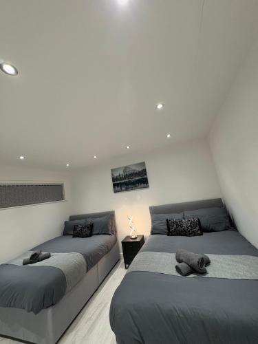 two beds sitting in a room with white walls at Luxury modern guest house in Birmingham