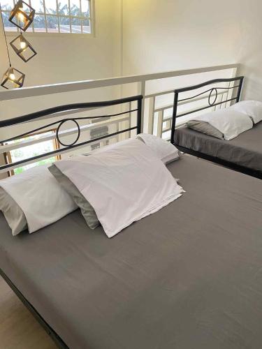 a bedroom with two beds with white pillows at Benido Farm - A Secret Haven in San Jose