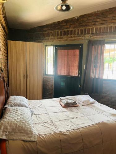 a large bed in a room with two windows at El Resguardo in San Luis