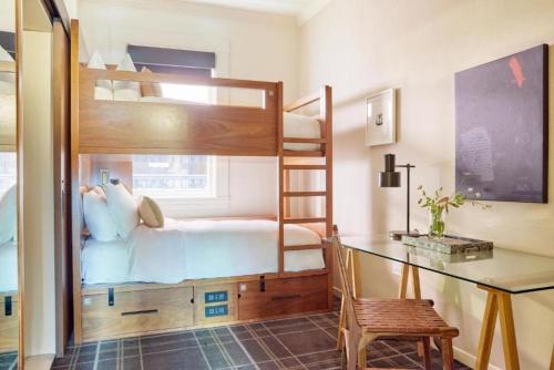 a bedroom with a bunk bed with a desk and a chair at Bposhtels San Francisco in San Francisco