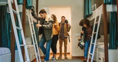 a group of people standing in a room with bunk beds at Bposhtels San Francisco in San Francisco