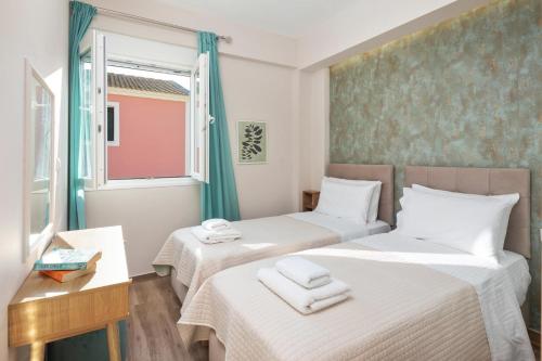 two beds in a small room with a window at Erato by Vintage Travel in Tsoukalades
