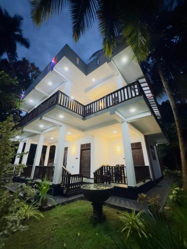 a large white house with a fountain in the yard at Moonlit serenity Tangalle in Tangalle