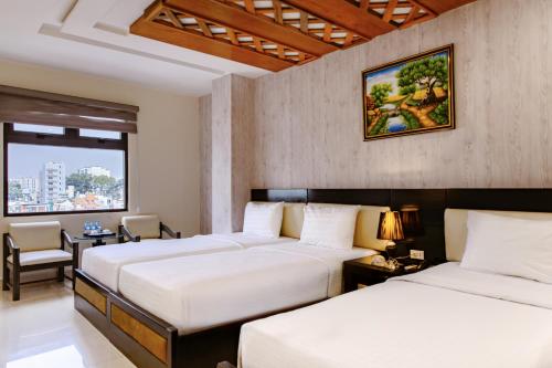 a hotel room with two beds and a window at Boss Palace Hotel in Ho Chi Minh City