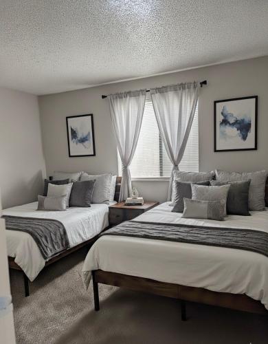 a bedroom with two beds and a window at Sports Fan Getaway less than 2mi to AT&T Stadium Pool and Gym! in Arlington