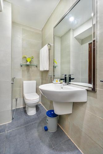 a bathroom with a sink and a toilet and a mirror at Lohas Beach Villa in Kalutara