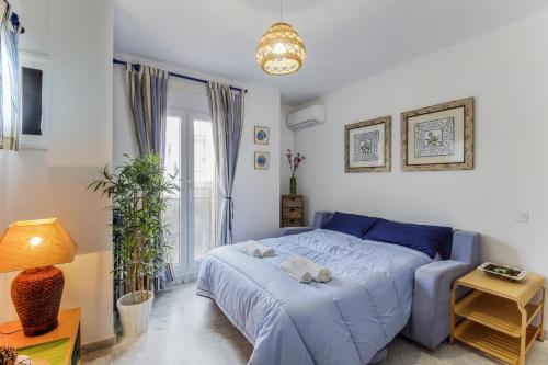 a bedroom with a blue bed and a window at La VICTORIA Home free parking by Cadiz4Rentals in Cádiz