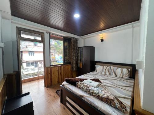 a bedroom with a bed with a wooden ceiling at Hangkhim Homestay in Ravangla