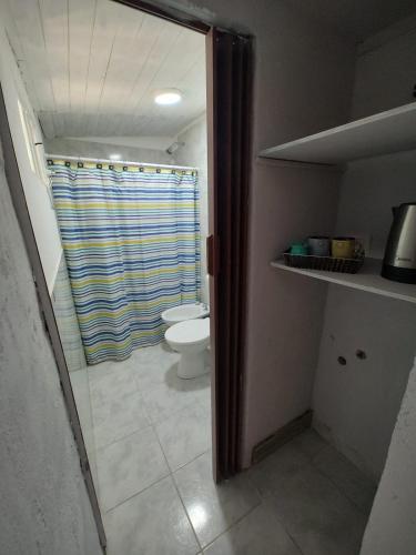 a bathroom with a toilet and a shower curtain at brisa azul in General Roca