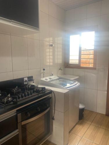 a white kitchen with a sink and a stove at Posada - Letiéle in São Gabriel