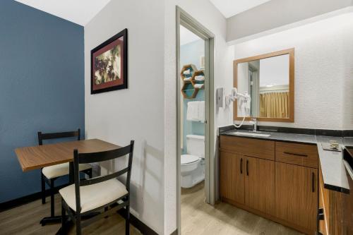 a bathroom with a table and a sink and a toilet at HomeTowne Studios by Red Roof Buffalo - Niagara Airport in Williamsville