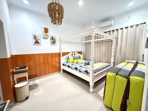 a bedroom with a white bed with yellow pillows at Homestay Aesthetic Jogja in Gondowulung