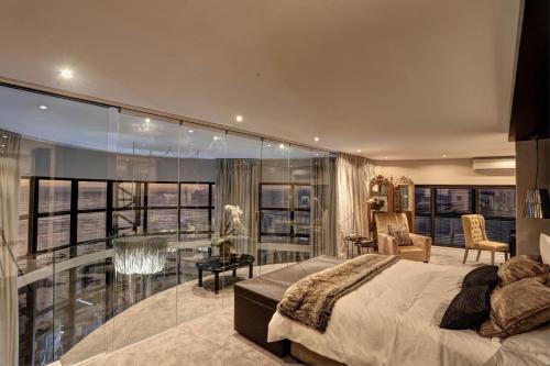 a bedroom with a bed and a glass wall at Ocean View Penthouse in Strand
