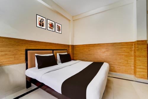 a bedroom with a large bed with wooden walls at Super Hotel O Kollamkudimughal Kakkanad Formerly Diamond Inn in Kakkanad
