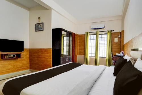 a bedroom with a large bed and a tv at Super Hotel O Kollamkudimughal Kakkanad Formerly Diamond Inn in Kakkanad
