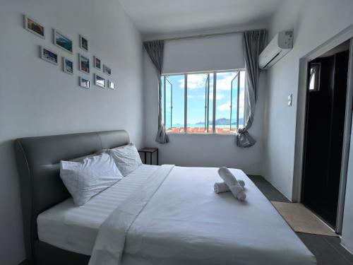 a bedroom with a white bed with a window at Langkawi Simfoni Premium Comfy 09 in Kuah