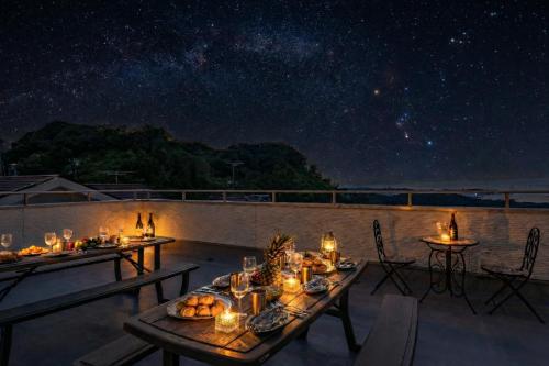 a table with food and candles on a patio at night at PEACE OF REST SHIRAHAMA in Shirahama