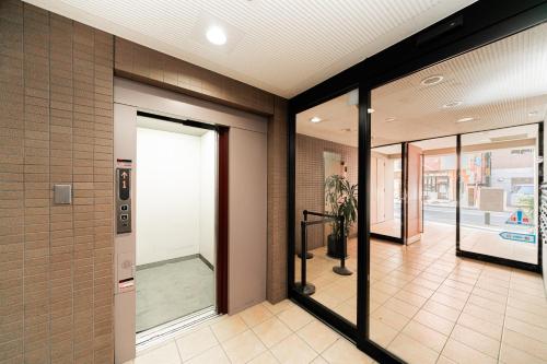 a hallway with glass doors in a building at Kamata Opus2 Apartment in Tokyo