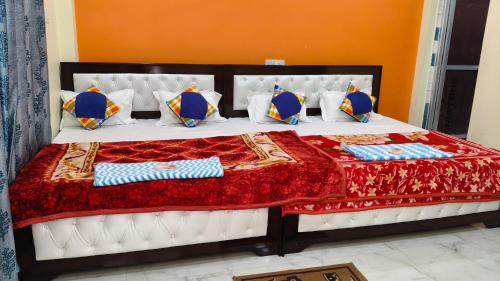a large bed with a red and blue comforter and pillows at Sri Narayan Home Stay in Ayodhya