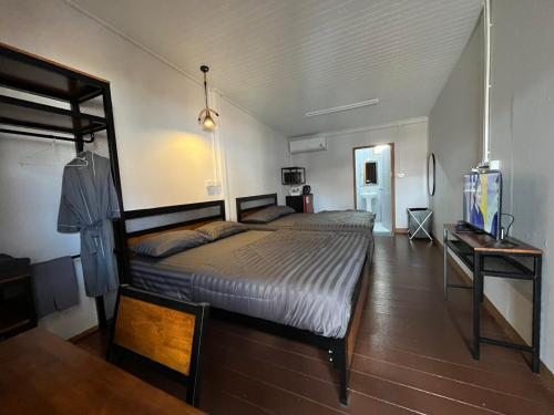 a bedroom with a large bed and a table at Jin Pool Villa in Ban Khok Chakohan