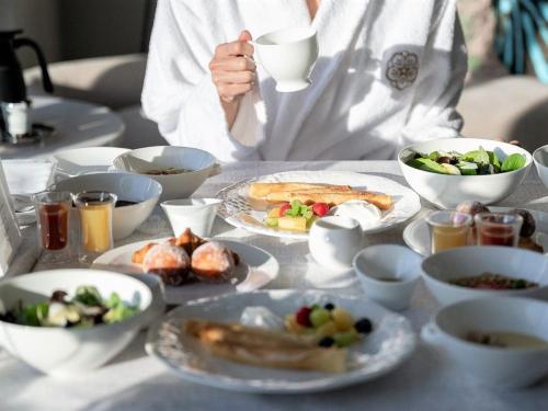 a person sitting at a table with plates of food at The Kahala Hotel & Resort Yokohama in Yokohama