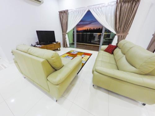 a living room with two couches and a television at Luxury Condominium at Loft Imago in Kota Kinabalu