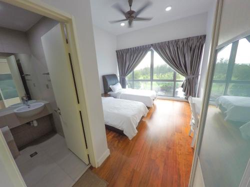 a bedroom with two beds and a sink and a mirror at Luxury Condominium at Loft Imago in Kota Kinabalu
