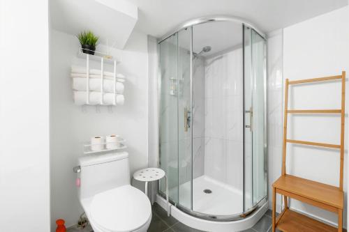 a white bathroom with a shower and a toilet at BudgetWise Semi-Basement near Airport, UBC, Downtown in Vancouver in Vancouver