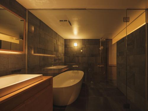 a bathroom with a tub and a sink and a shower at Good Fellows Resort in Kagoshima