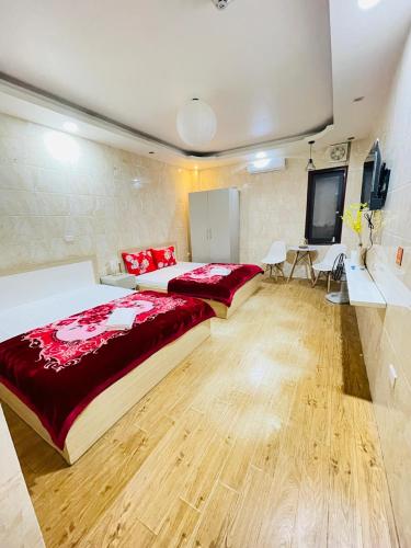 a large bedroom with a large bed with red sheets at Duyen Motel in Hanoi