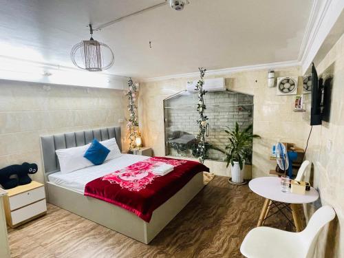 a bedroom with a bed with a red blanket and a table at Duyen Motel in Hanoi