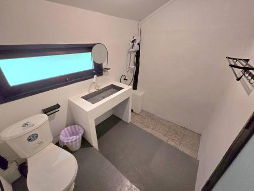a bathroom with a white toilet and a sink at บ้านสุจิปุรี BaanSujipuri in Pak Chong