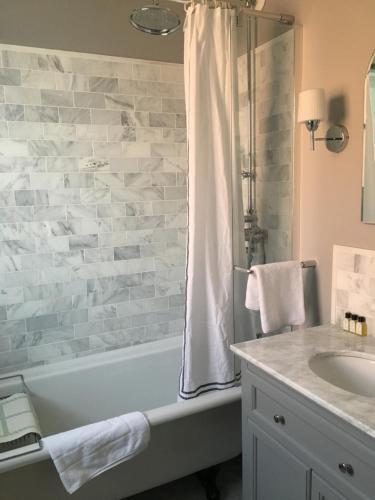 a bathroom with a bath tub and a sink at Balham Lodge in London