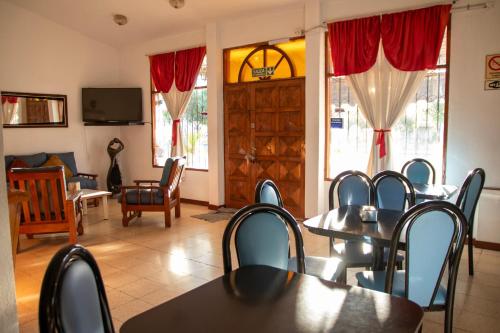 a dining room with tables and chairs and a tv at Hotel Barcelona in General Alvear