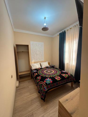 a bedroom with a bed with a colorful blanket at KALA Khiva in Khiva