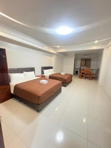 a bedroom with two beds and a table and chairs at Guest hotel Palestina Pili in Pili