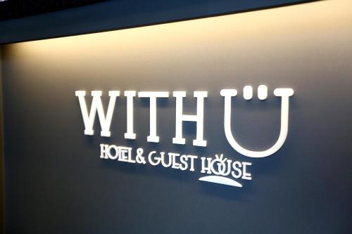 a sign for a whittili logo and guest house at With U Hotel & Guesthouse in Sokcho