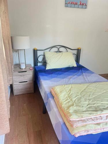 a bedroom with a bed and a night stand with a lamp at Baan Phakdee in Ban Phlong Takhe