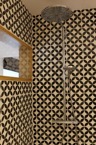 a bathroom with a black and white patterned wall at Un Air de Château in Spa