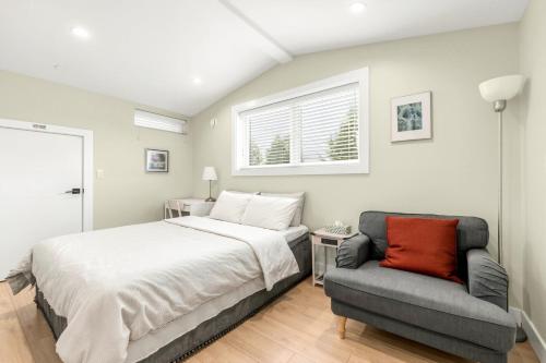 a bedroom with a bed and a couch and a window at New laneway house near Airport, World Cup stadium, Downtown, UBC in Vancouver
