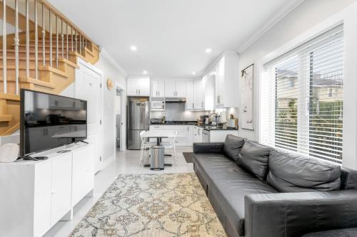 a living room with a couch and a kitchen at New laneway house near Airport, World Cup stadium, Downtown, UBC in Vancouver
