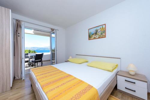 a bedroom with a bed and a view of the ocean at Apartments Aida in Cavtat