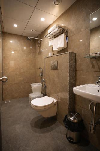 a bathroom with a toilet and a sink at Solasta Stays and Banquet - Wakad in Pune