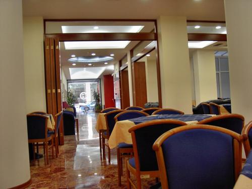a dining room with tables and chairs and a hallway at Hotel Elena in Lamía